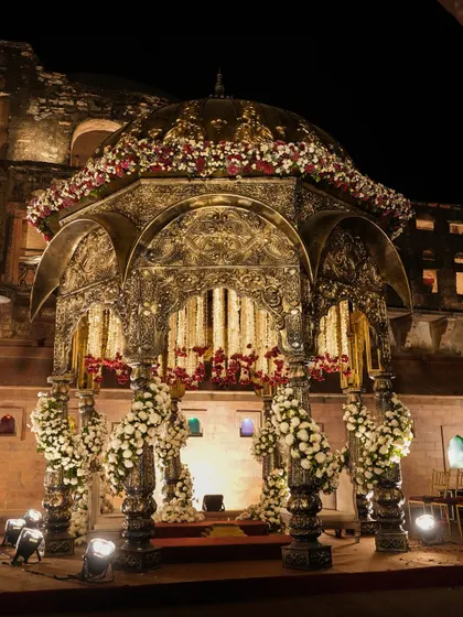 A full view of the magnificent Khimsar mandap, set against the historic fort walls. The lighting was designed to highlight the intricate carvings and create a dramatic, regal atmosphere.