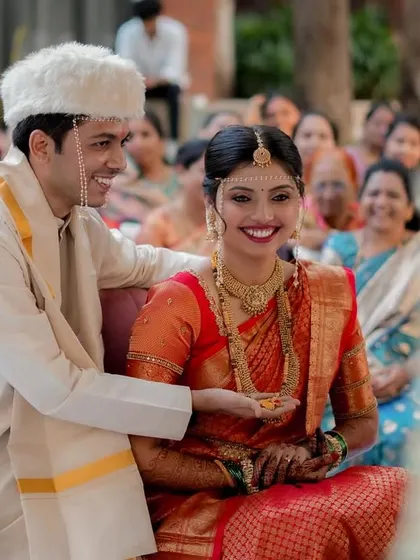 A candid moment of laughter and joy during the wedding rituals. The groom's smile as he interacts with his bride is heartwarming.
