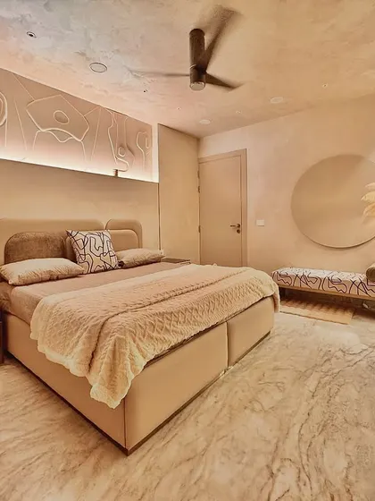 This bedroom is a retreat designed for maximum calm. The walls are finished with a soft, lime-wash texture, and the color palette is warm and earthy. I designed the space with minimal forms, like the backlit wall art and custom bench, to create a quiet, soulful environment that feels like a gentle embrace.