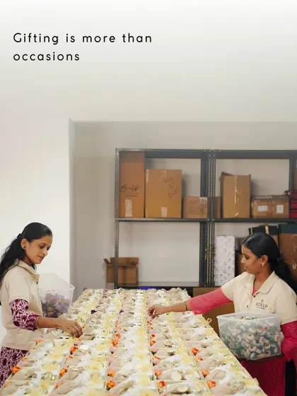 Gifting is more than occasions. Two of our team members carefully arrange items for a large order, showcasing the scale and precision of our work.
