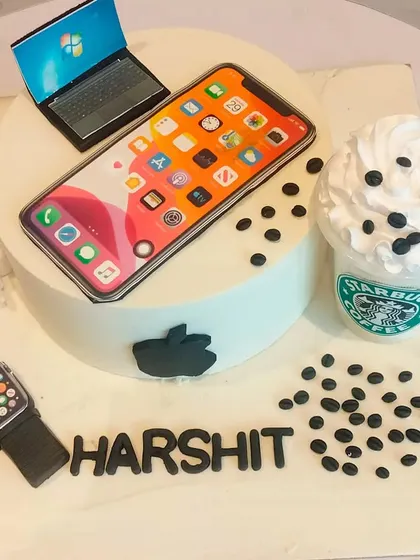 The ultimate cake for a tech enthusiast. This design features edible replicas of an iPhone, Apple Watch, laptop, and a Starbucks coffee, representing all the modern-day essentials.