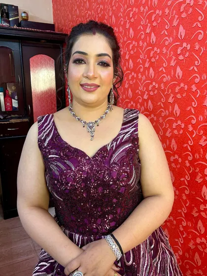 A smiling portrait of the happy client in her rental gown, ready for her event.