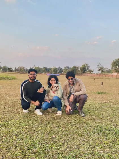 Friends and their furry companion posing for a group photo in our spacious park.