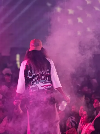 A shot from behind, showing the back of my custom jacket as I'm surrounded by purple smoke on stage.