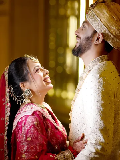 A joyful, candid moment between the bride and groom, sharing a laugh.