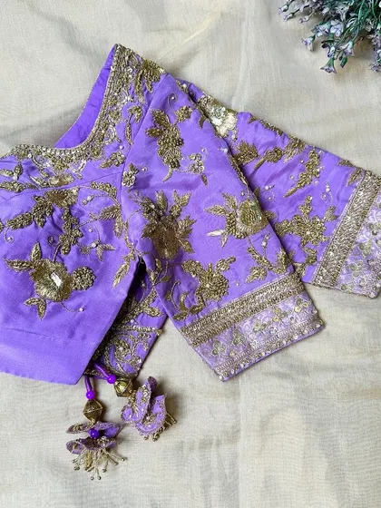 A gorgeous purple blouse with all-over golden zari embroidery.