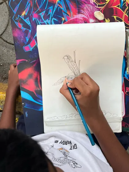 An overhead view of a student sketching a plant. This close-up shows the careful line work involved in capturing the details of natural forms.
