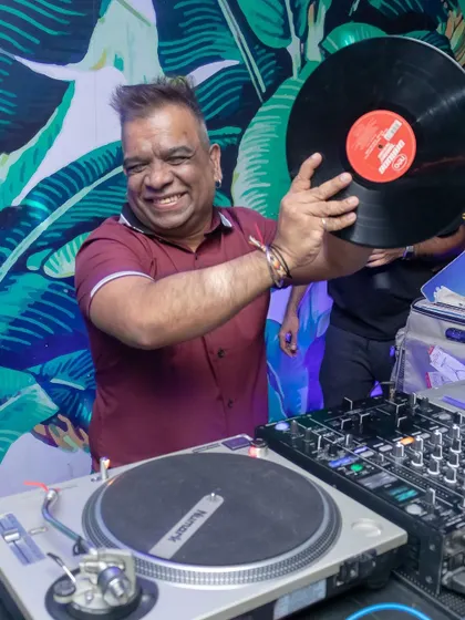 Holding up a classic house record with a huge smile. Playing vinyl on my Technics turntables brings back so many great memories.
