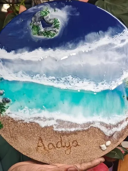 The full view of the 'Aadya' resin art piece, held to show its size and vibrant colors.