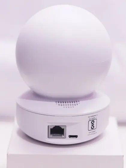 The back of this smart camera shows the ports for power and an ethernet cable, offering flexible connection options. It is also certified for quality and safety standards.