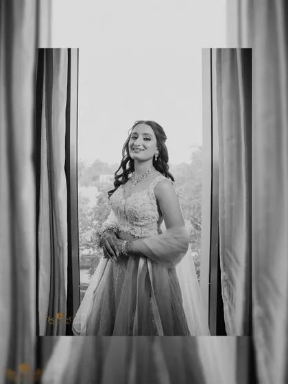 A beautifully framed portrait of the bride looking out a window. The black and white edit adds a timeless and classic feel to this engagement photo.