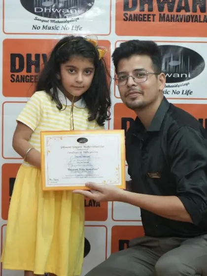 A teacher presents an award to his young student.