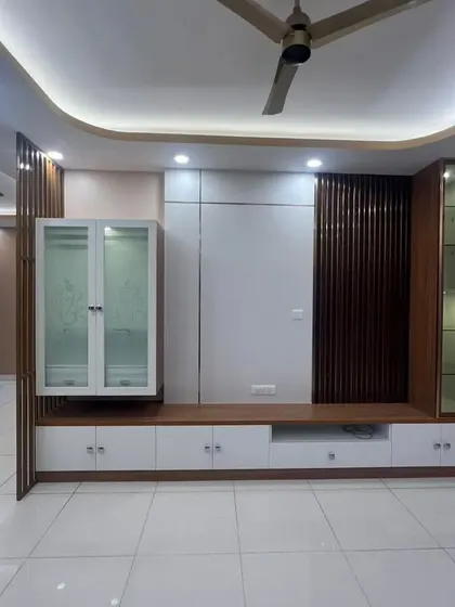 This TV unit combines a display niche for a pooja idol with practical storage and a decorative partition, demonstrating our skill in creating multi-purpose furniture.