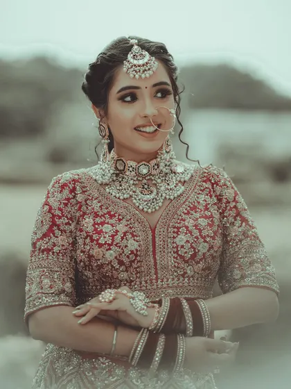 A candid moment where the bride's natural smile and personality shine. This outdoor portrait captures her looking away, giving a sense of genuine emotion and anticipation.