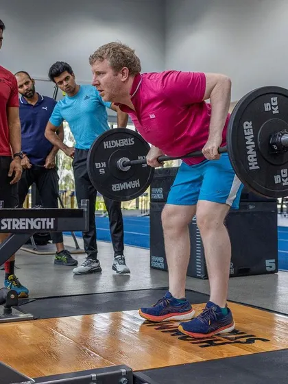 An assessor demonstrates proper technique for a bent-over row during the UKSCA course.