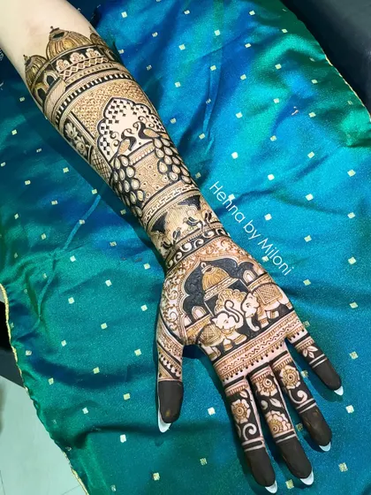 A stunning bridal mehendi with elephants, peacocks, and architectural details. The dark, bold application ensures a beautiful, long-lasting stain.
