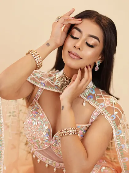 A serene, eyes-closed portrait that showcases the soft, shimmery eyeshadow and the glowing, contoured cheeks.