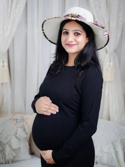 A chic solo portrait with the mom-to-be wearing a stylish hat. This adds a touch of personality and fashion to the maternity session.