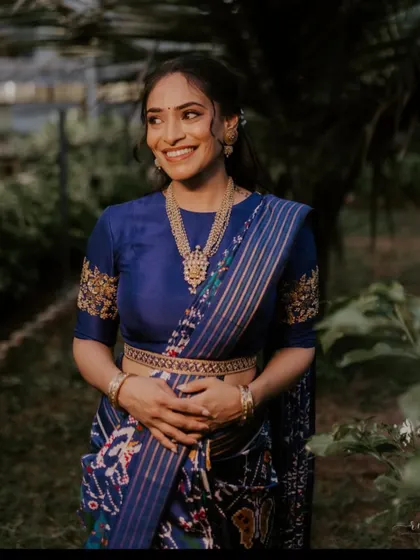 This client is wearing a royal blue saree with a matching blouse that features delicate gold embroidery on the sleeves, a subtle yet elegant touch.