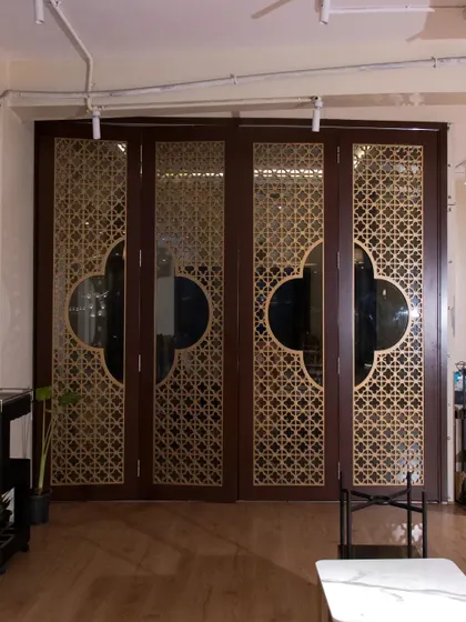 Another angle of the four-panel folding 'jali' doors, showing how they can be used to create a flexible and artistic partition between spaces.