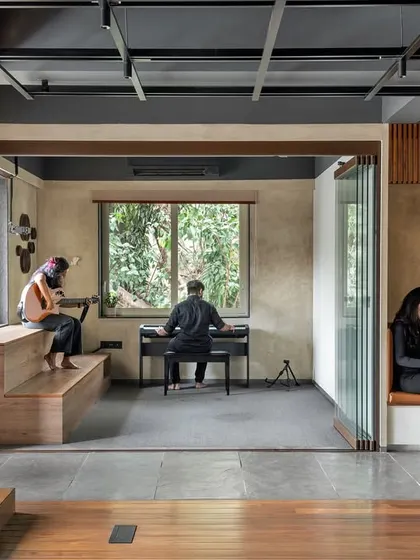 We designed this creative incubator to be a fluid environment that fosters both collaboration and individual focus. This view shows how different activities can coexist harmoniously, with a dedicated music and recording area flowing into a quiet reading nook.