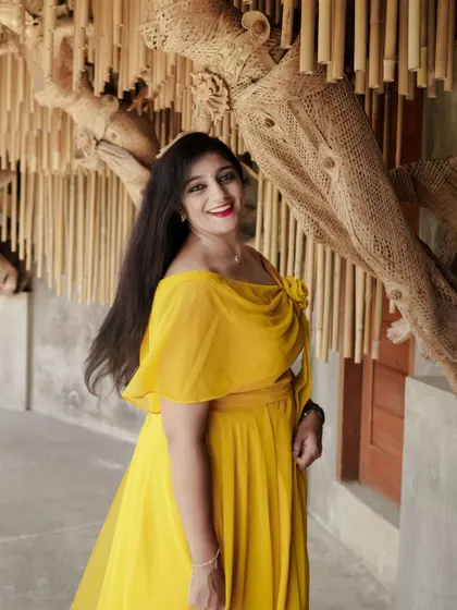 A close-up of the client, her smile as bright as her beautiful yellow gown.