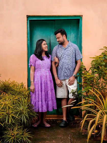 A full-frame shot of the couple against a rustic teal door, showcasing the charming architecture of the location.