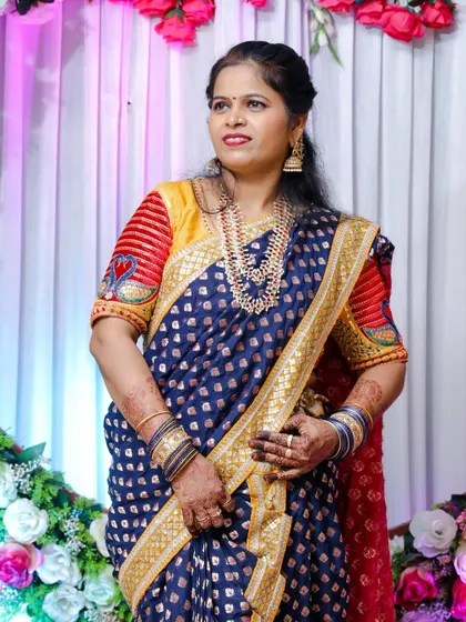 A close-up of the client in the blue Nauvari, showing her happiness and the detailed jewellery.