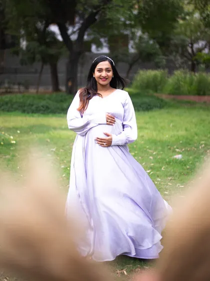 A solo maternity portrait is a beautiful way to celebrate your journey. This mom-to-be is wearing a flowy lavender gown that catches the light perfectly in this outdoor park setting. I guide my clients with simple movements, like a gentle twirl, to create images that feel joyful and full of life.