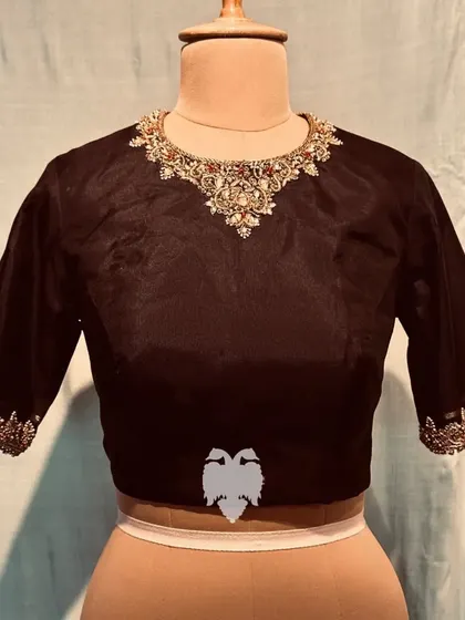 The front of the black silk blouse, featuring a necklace-inspired jeweled collar.