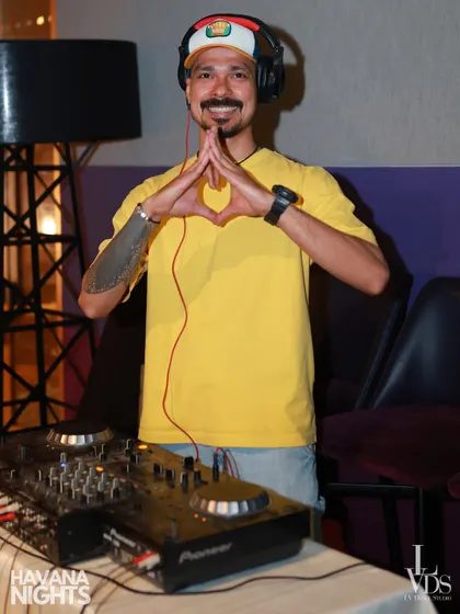 The heart of the party! Our DJ, with a prosthetic arm, making a heart sign from behind the decks, showing that passion for music and dance has no limits. He keeps the Latin beats flowing all night.