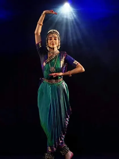 A student performing under a spotlight, her form illuminated. This image is a tribute to our late costume tailor, Manjunath, whose craftsmanship brought our visions to life.