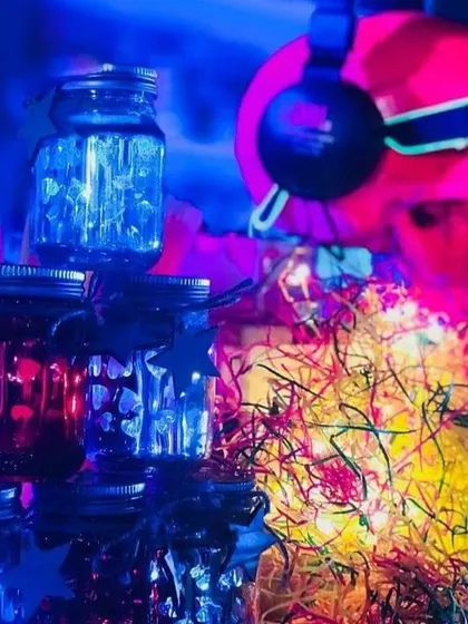 A close-up of the neon-drenched decor. Mason jars filled with lights and a skull wearing headphones contribute to the vibrant, glowing aesthetic of the retro disco theme.