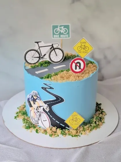 Ride in the direction of your dreams. This cake is for a cycling enthusiast, featuring a bike route, road signs, and a cyclist in action.