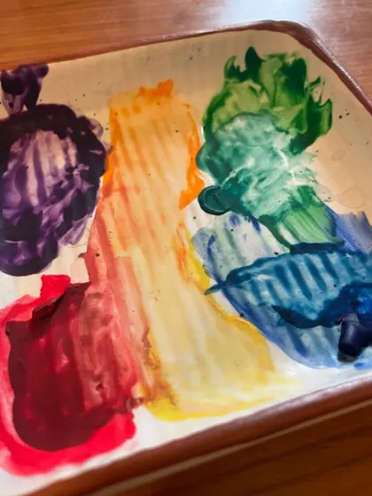 A palette full of vibrant, messy colours. This is the aftermath of a creative session, and I love it.