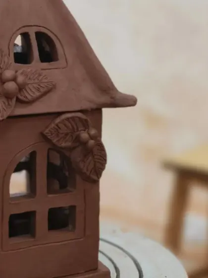 Another angle of the hand-built lantern, highlighting the carefully cut-out windows and the texture of the clay. These pieces are as beautiful unlit as they are when glowing.