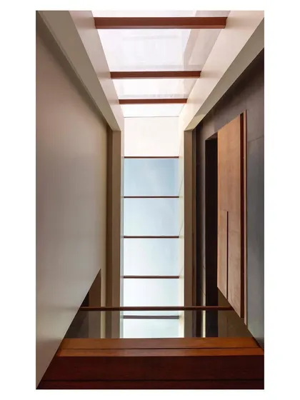 Looking up through the ribbon skylight in the 'House with Parallel Planes'. This architectural feature is central to the home's design, drawing the sky into the very heart of the building and illuminating the main circulation spine.