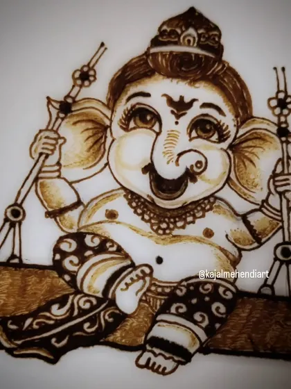 A close-up of the cute Ganesha figure on a swing. Notice the playful expression and the intricate details on the clothing and swing, all created with a henna cone.