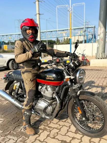 Ready to roll on a Sunday morning. The red helmet adds a pop of color to the full riding gear.