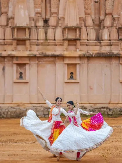 The iconic 'chakkar' or spin of Kathak, captured mid-motion. The flowing skirts of our costumes accentuate the speed and grace of the turn, creating a beautiful circular form.