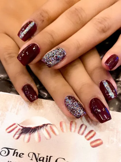A chic and simple design on short, square nails. The deep maroon polish is paired with accent nails fully covered in multi-tonal silver glitter.