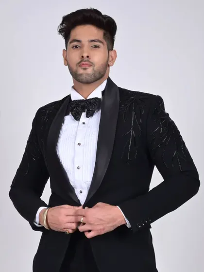 A confident pose in our custom black tuxedo. The fit is tailored to perfection, ensuring a sharp silhouette for any formal occasion.