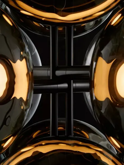 A detailed, abstract view of the Aeris fixture, showing the intersection of the glass spheres and the dark metal structure. The design creates a beautiful play of reflection and light.