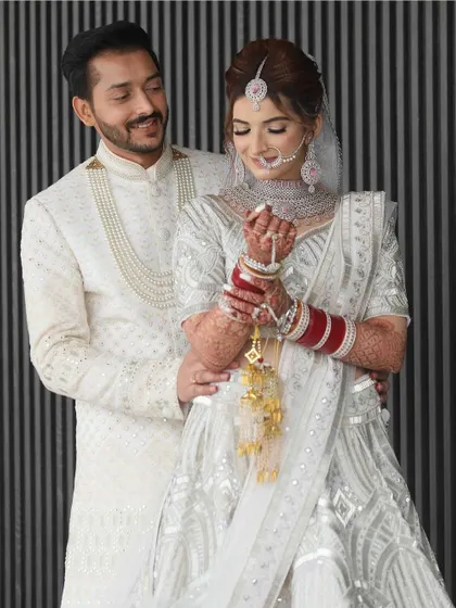 A sweet moment between the bride and groom. Her makeup looks soft and romantic, perfect for this intimate shot.