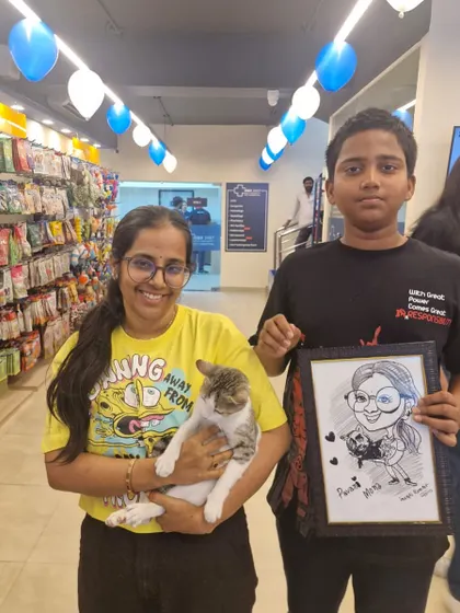 Another happy family at Meow Fest, holding their cat and a personalized caricature portrait created at the event.