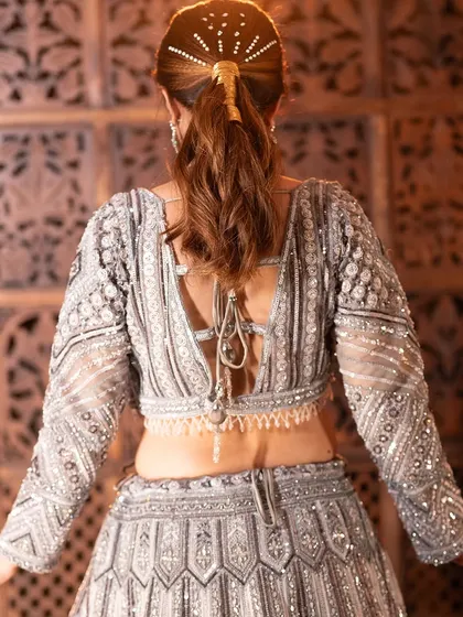 The back view of the lehenga, highlighting the beautiful hairstyle and the elegant cut of the blouse.