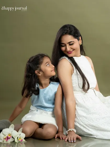 A quiet moment of connection. A daughter looks up at her mother with so much love, a beautiful and intimate portrait of their bond.