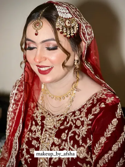 The pure joy on a bride's face is everything. Her makeup is classic and radiant, with a bright red lip and shimmery eyes that light up her smile.