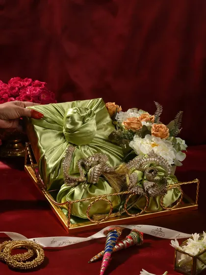 Celebrate the glow of Teej with my handcrafted hampers. This one features gifts wrapped in beautiful green satin furoshiki style, placed in a golden tray with floral arrangements to speak the language of love and light.