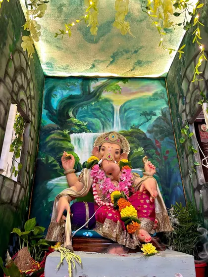 A different angle of the waterfall-themed decoration, showing the painted ceiling that adds to the immersive effect. The hanging vines with fairy lights make the space feel magical and alive.